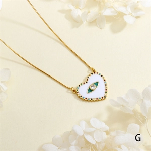 Detailed macro view of gold heart necklace with zircon evil eye pendant and dried flowers
