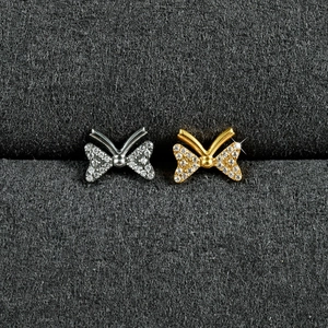 Détail de piercings de lèvre papillon en titane G23 doré et argenté sertis de zircons