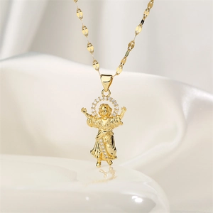 Macro view of 18K gold plated Divino Niño pendant with zircon stones on silk