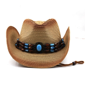 Detail of wide brim straw cowboy hat featuring blue turquoise stone and beaded band