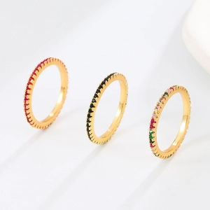 Trois bagues dorées avec zircons rouges, noirs et multicolores sertis de pierres