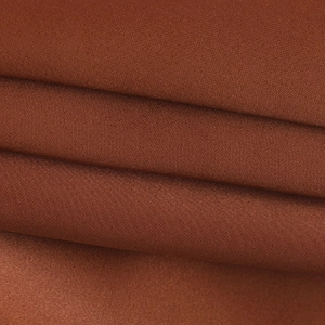 Détail macro du tissu tissé brun rougeâtre haute densité montrant la texture et le drapé