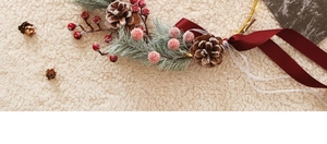 Detail of Christmas wooden plaque with red berries, pine cones, and needles