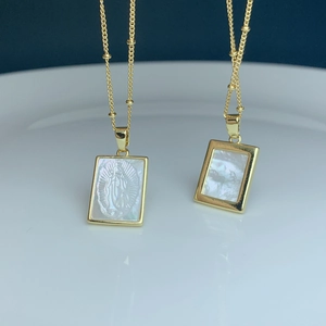 Detailed macro view of Guadalupe pendant with mother of pearl inlay and beaded gold chain