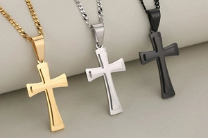 Detailed macro view of double-layered cross pendants in gold, silver, and black finishes