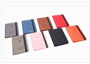 Travel passport holders in multiple colors with embossed design and elastic strap closures