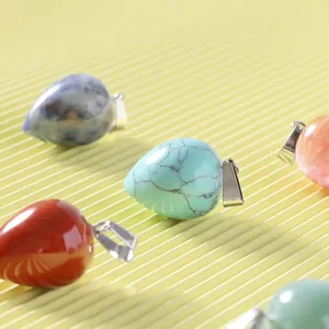 Teardrop natural crystal agate pendants with silver clasps on textured background
