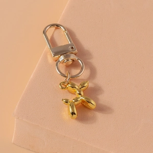Detailed view of golden balloon dog keychain with lobster clasp and metallic finish