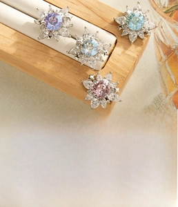 Macro shot of silver flower earrings with multi-colored crystals and marquise zircons