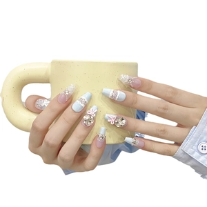 Handmade light blue press-on nails with 3D bows and rhinestones in ballerina shape