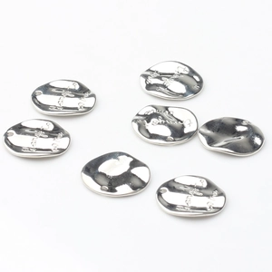 Close-up of pebble-shaped silver plated alloy pendants with textured surface for DIY jewelry