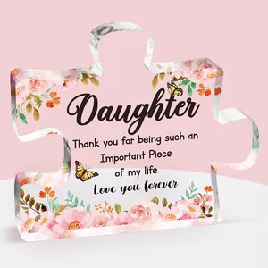 Macro view of transparent acrylic puzzle plaque with floral patterns and emotional message