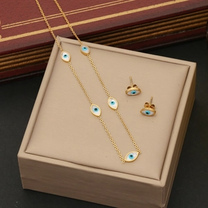 Golden stainless steel necklace and earrings set with evil eye patterns in a box