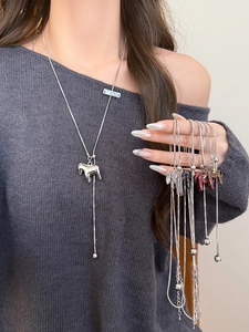 Detail view of stylish stainless steel pony charm necklaces in various colors on a model