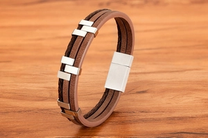 Macro detail of brown braided leather layers and silver magnetic clasp for men's bracelet