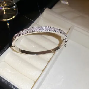 Silver rectangle clasp bangle with sparkling zircon pave set on white velvet background