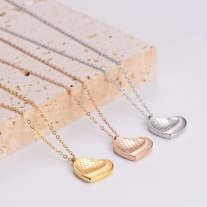 Honeycomb heart necklaces in gold, rose gold and silver finishes on a textured stone