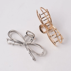 Golden and silver metal butterfly bow claw clips with glossy finish on white background