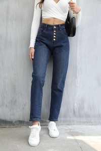 Dettaglio dei jeans blu scuro a vita alta con patta a cinque bottoni e taglio dritto