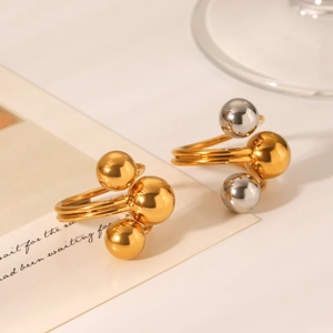 Detail of minimalist stainless steel rings with gold and silver ball geometric accents