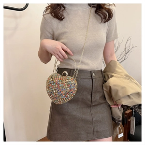Detailed close-up of heart-shaped rhinestone clutch with colorful crystals and gold handle