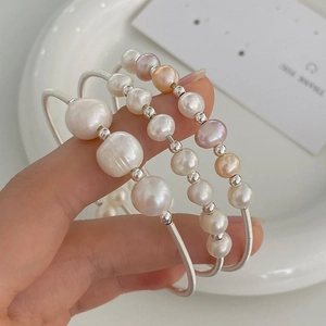 Detailed macro of a 3-piece set of natural freshwater pearl spring bracelets in three colors