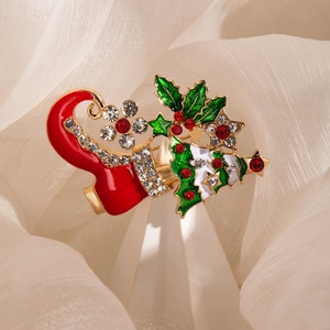 Macro detail of Christmas boot brooch with holly leaves and sparkling rhinestones