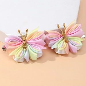 Detail of handmade colorful butterfly hair clips with layered ribbon and gold wire antennas