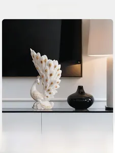 Detail of white peacock sculpture with golden trim and layered feather textures