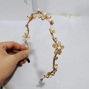 Detail eines goldenen Blumen Stirnbands mit Kristallperlen, weißen Perlen und Strasssteinen
