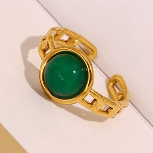 Macro detail of vintage gold chain ring featuring a round emerald green cabochon stone