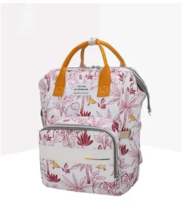 Detail of printed diaper bag featuring tropical elephant patterns and yellow top handles