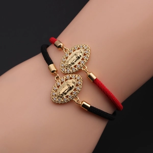 Detail von rot-schwarzen gewebten religiösen Armbändern mit goldenen Maria-Anhängern