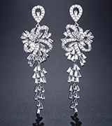 Detail of silver long tassel earrings featuring a bow design and shimmering rhinestones