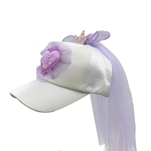 Dettaglio cappellino in raso bianco per bambini con ricamo a cuore, corona e velo viola