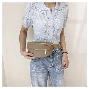 Detail of light brown leather waist bag with gold zipper and adjustable wide strap
