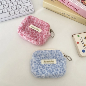 Dettaglio di portamonete in peluche leopardato rosa e blu con chiusure a cerniera ad anello