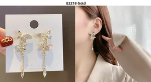 Detail of long gold butterfly tassel earrings featuring sparkling zircon and teardrop crystal
