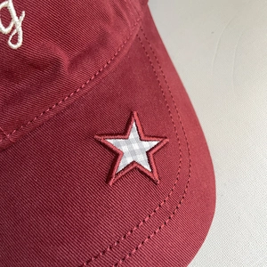 Detailed macro of vintage star embroidery on high-quality burgundy cotton baseball cap