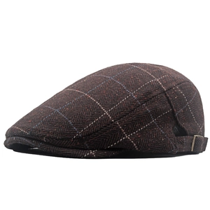 Detail of British brown herringbone tweed beret showing the metal adjustable side buckle