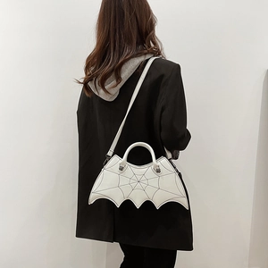 Gothic white bat-shaped PU leather bag with spider web stitching on model's shoulder