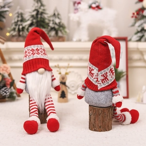 Detailed view of red and grey knitted Christmas gnomes with striped legs on a festive mantle