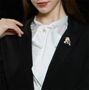 Detail of magpie bird brooch with colorful crystals pinned on a black suit lapel