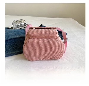 Detail view of pink corduroy mini backpack showing durable base and textile texture