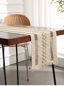 Close-up of bohemian cotton linen table runner with geometric weaving and tassels