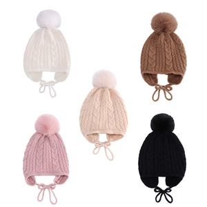Detail view of cable knit baby hats with faux fur pom-poms in five assorted colors