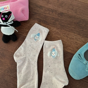 Close-up of beige cotton socks with colorful flecks and cute cartoon embroidery