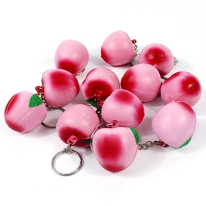 Close-up of pink peach fruit keychains with realistic texture and metal link chain