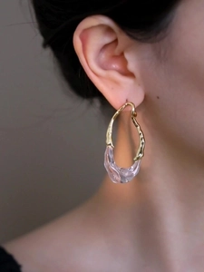 Gros plan de la boucle d'oreille goutte plaquée or 18k avec résine rose sur modèle