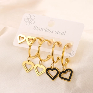 Three pairs of 18K gold-plated heart earrings and black enamel charms on display